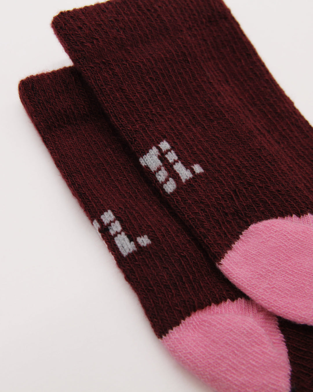 Knitting details of burgundy and pink baby socks