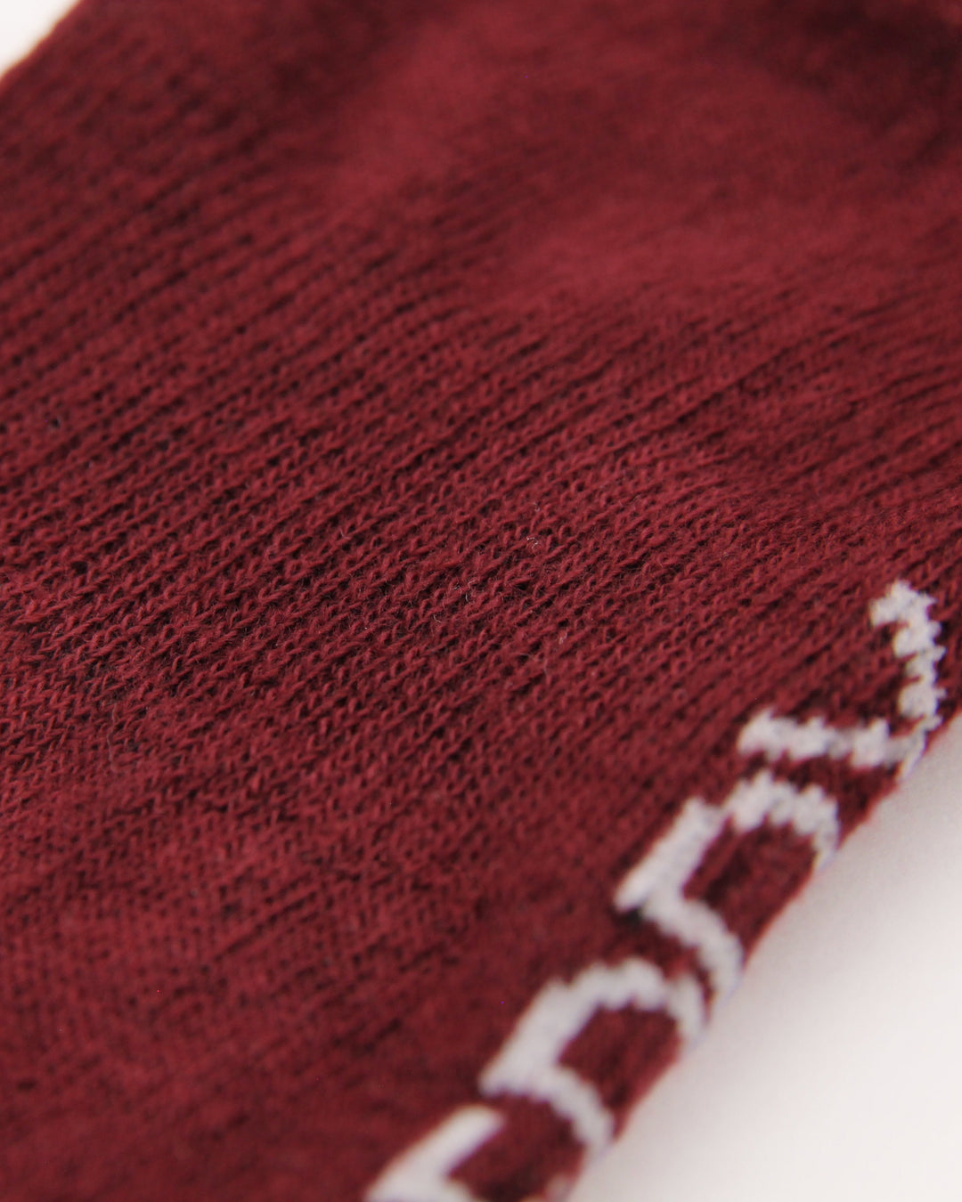 Knitting details of arch support in the burgundy and pink ribbed crew socks