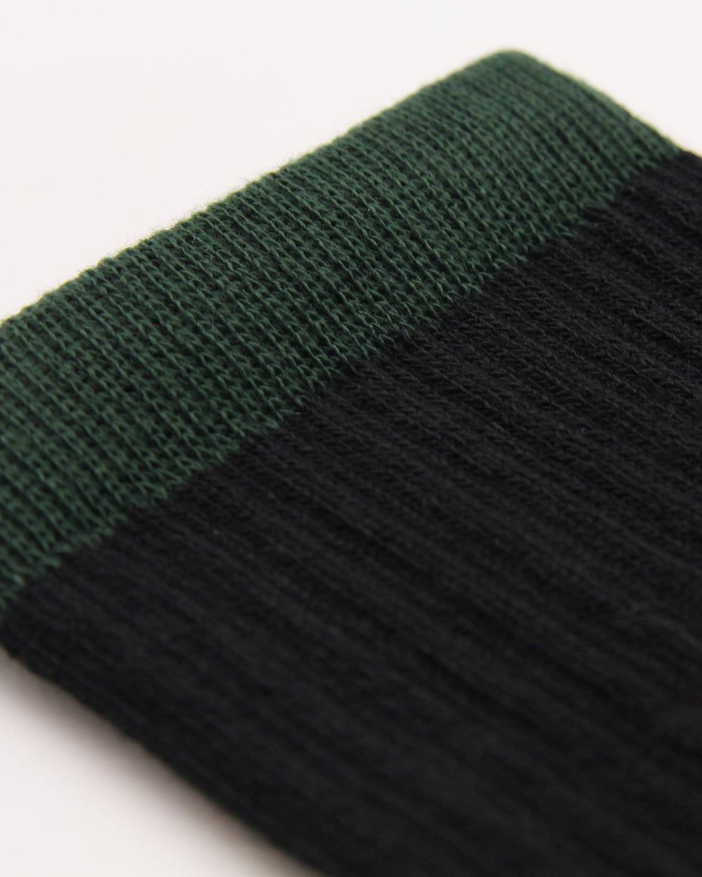 Close-up of black ribbed crew socks with green cuffs