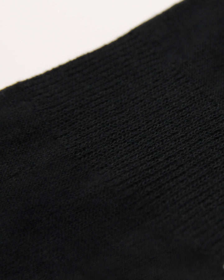 Close-up of knitted arch support in ribbed crew black Teddy Locks socks