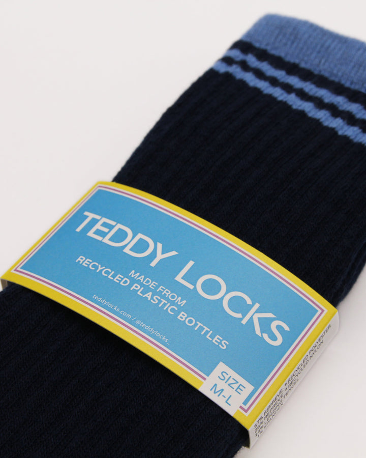 Pair of Navy and blue ribbed crew socks showing Teddy Locks made from recycled plastic bottles label
