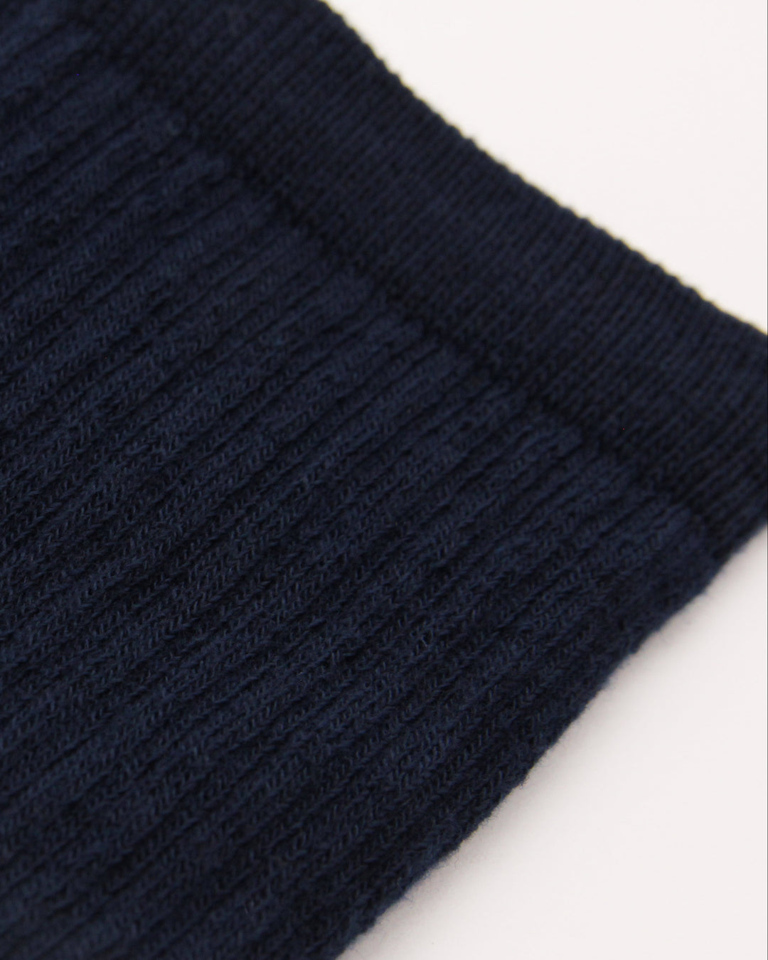 Close-up of navy blue ribbed crew socks with white detailing
