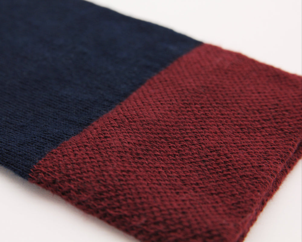 Close-up of two-toned navy and burgundy red sock, showing knitting detail